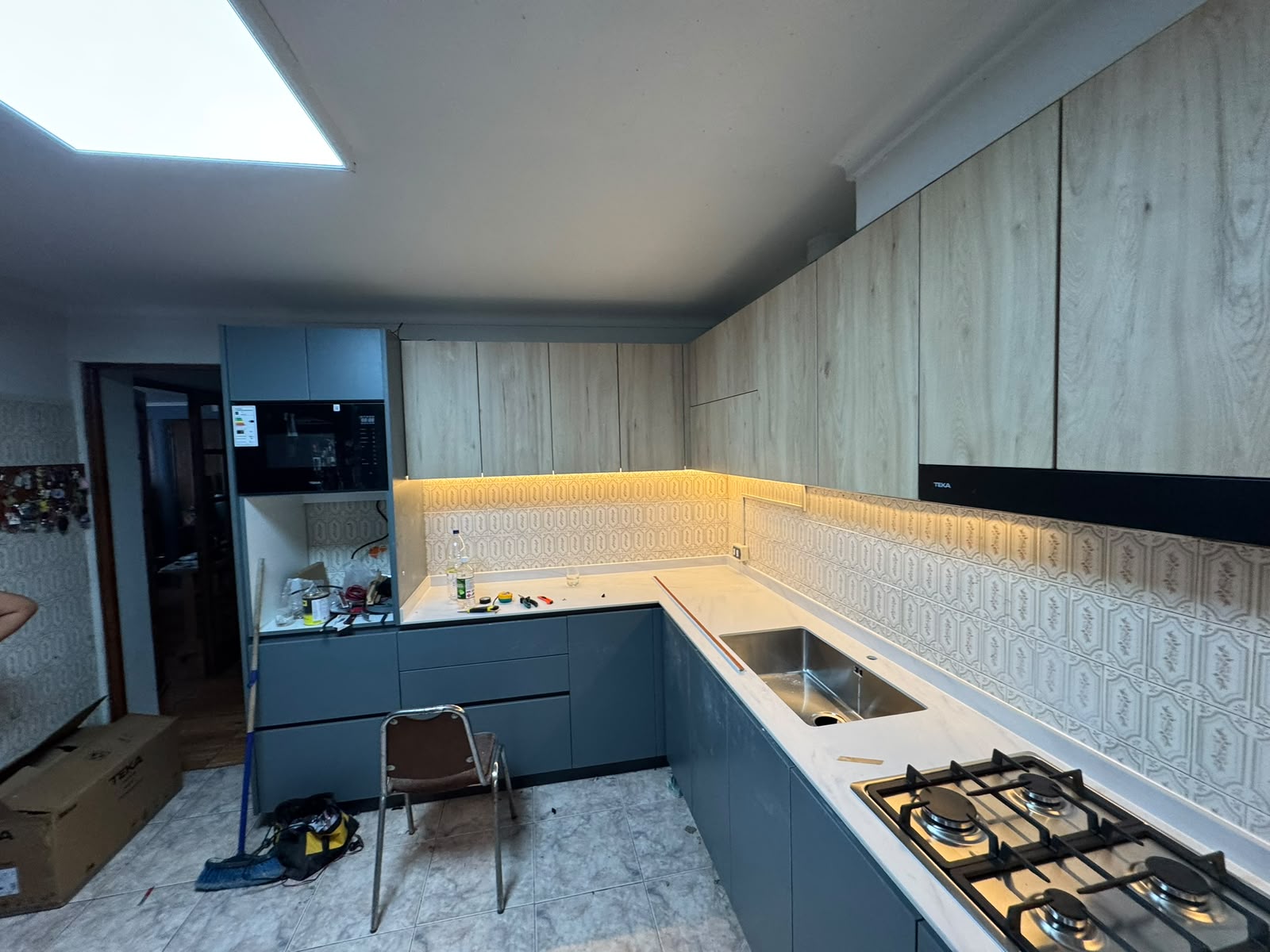 Cocina en instalación con luz LED y cubierta de cuarzo blanco